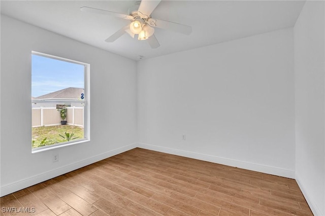 unfurnished room featuring healthy amount of natural light, light wood-style floors, and baseboards
