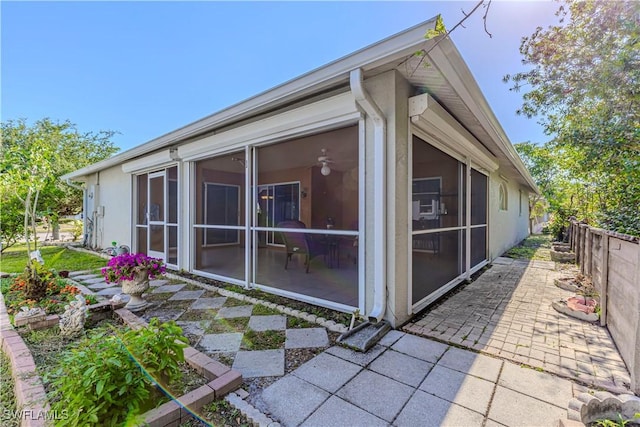 view of side of property featuring a sunroom and fence