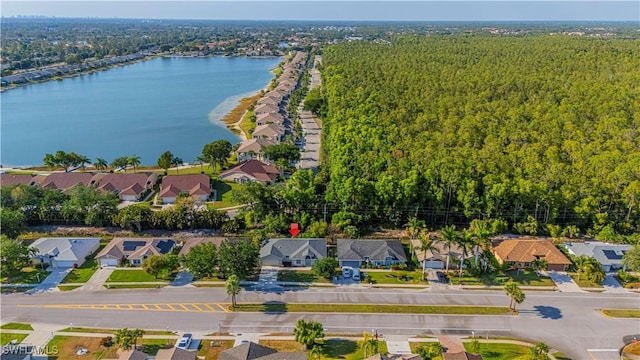 birds eye view of property featuring a residential view, a water view, and a wooded view