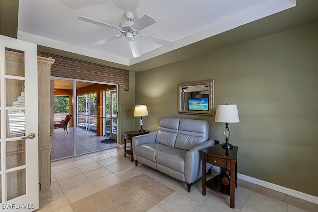 sitting room featuring light tile patterned floors, baseboards, and ceiling fan