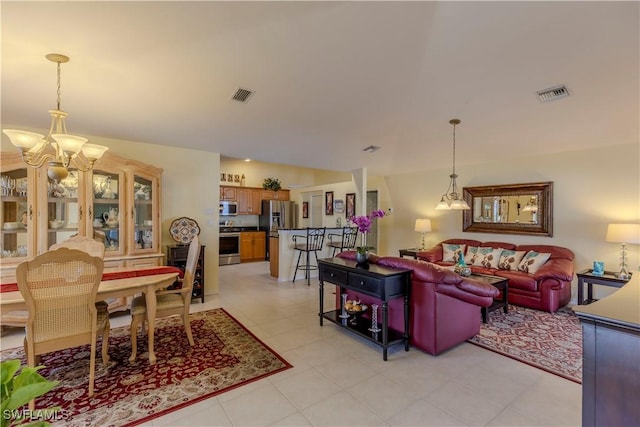 living area with light tile patterned floors, visible vents, and an inviting chandelier