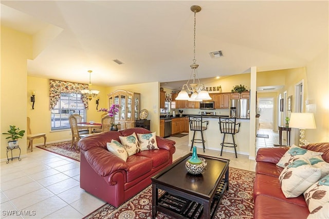 living area with light tile patterned floors, baseboards, visible vents, and a notable chandelier