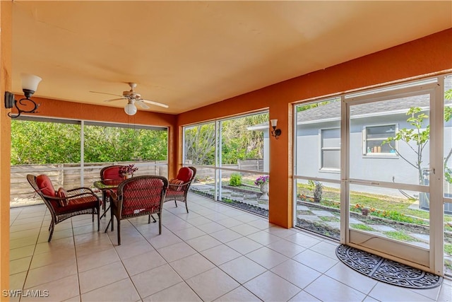 sunroom featuring ceiling fan and outdoor dining space