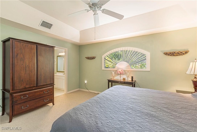 bedroom with visible vents, light carpet, baseboards, ceiling fan, and ensuite bath