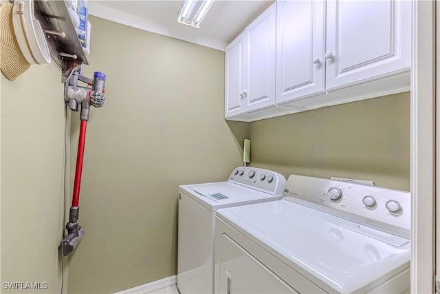 laundry area with separate washer and dryer, cabinet space, and baseboards
