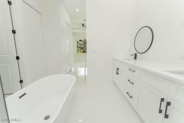 1412 5th Ave, Lehigh Acres, FL 33972 - bathroom with a freestanding tub, double vanity, baseboards, a ceiling fan, and recessed lighting