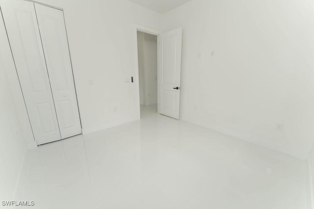 1412 5th Ave, Lehigh Acres, FL 33972 - unfurnished bedroom featuring light tile patterned flooring and a closet
