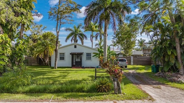 bungalow with fence, stucco siding, and a front lawn