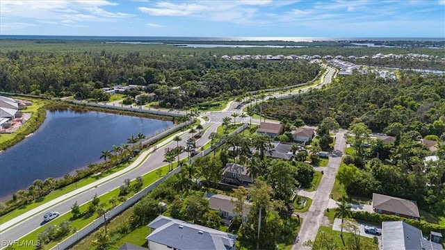 drone / aerial view featuring a residential view, a view of trees, and a water view