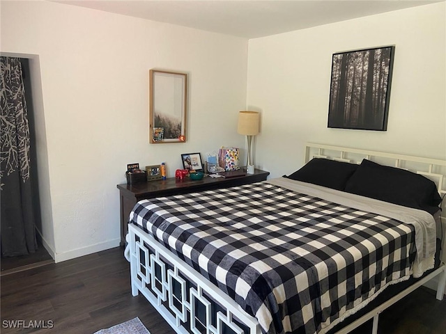 bedroom with dark wood-style flooring and baseboards