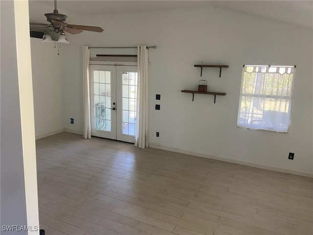 spare room featuring a ceiling fan, a healthy amount of sunlight, french doors, and lofted ceiling