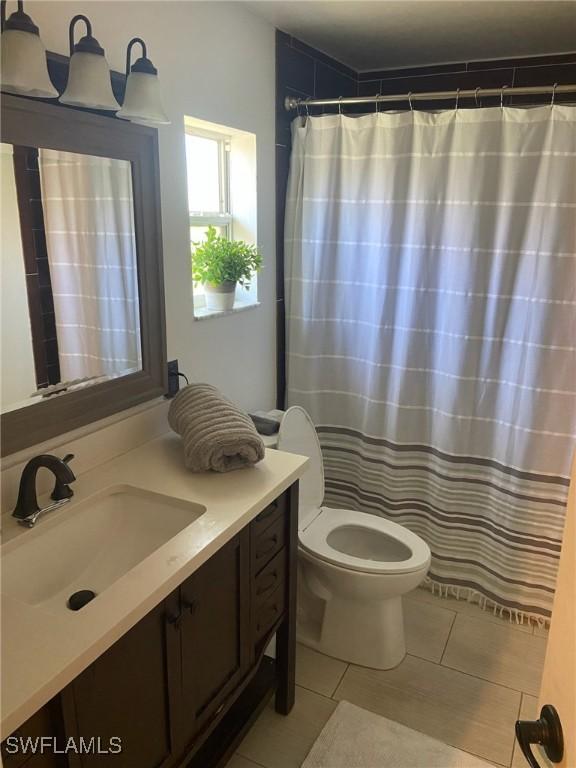 full bath with vanity, a shower with shower curtain, tile patterned floors, and toilet