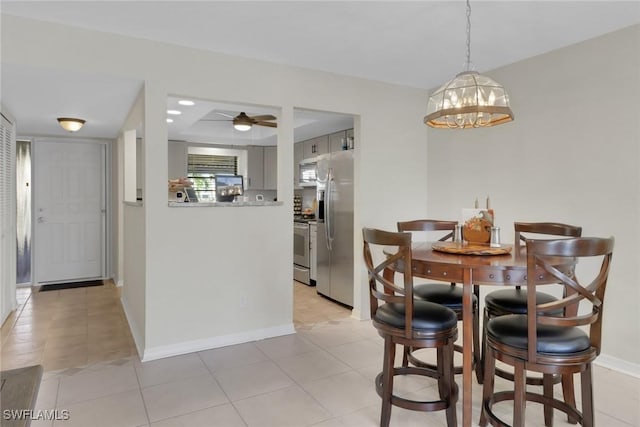 3720 SE 10th Ave Unit 102, Cape Coral, FL 33904 - dining space with baseboards, ceiling fan with notable chandelier, and light tile patterned floors