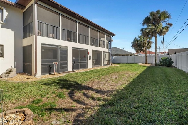3720 SE 10th Ave Unit 102, Cape Coral, FL 33904 - back of house featuring a lawn, a fenced backyard, stucco siding, and a sunroom