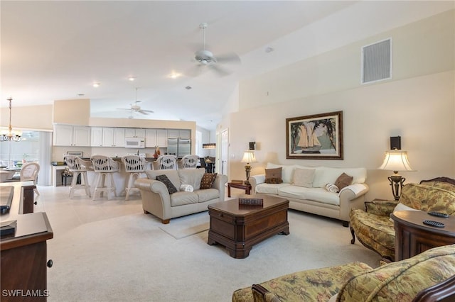 living area with light colored carpet, ceiling fan with notable chandelier, lofted ceiling, and visible vents