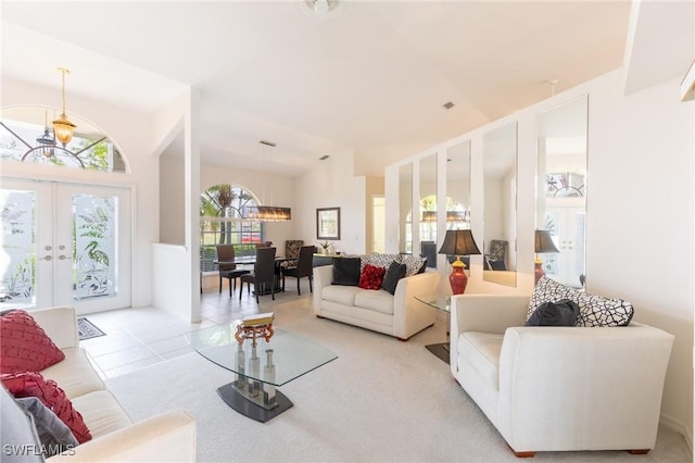 living area featuring vaulted ceiling, light tile patterned floors, an inviting chandelier, and french doors