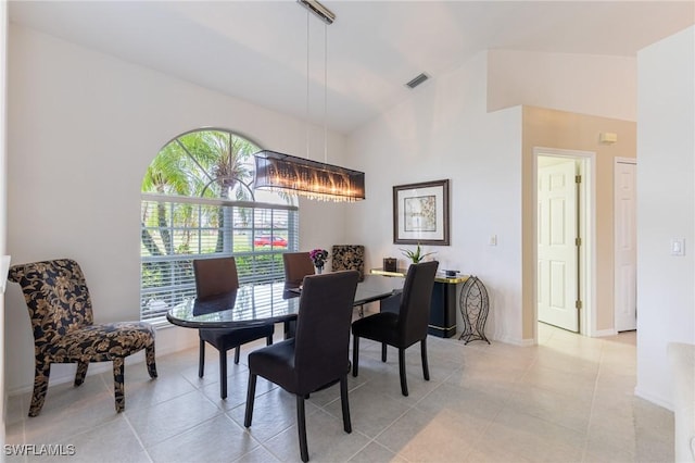 dining area featuring visible vents, light tile patterned floors, and high vaulted ceiling