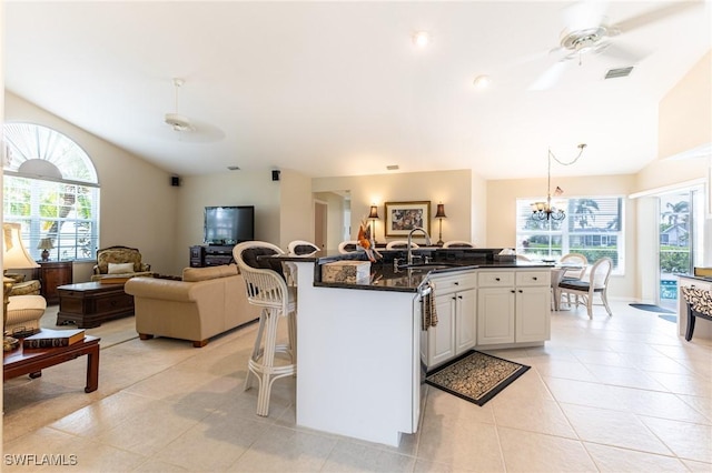 kitchen with a sink, a healthy amount of sunlight, a breakfast bar, and open floor plan