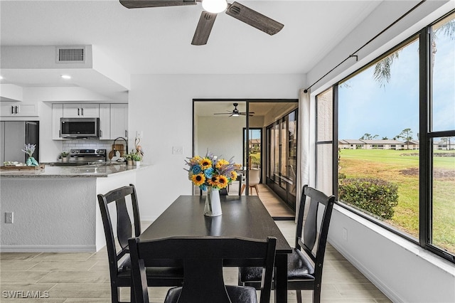 dining area featuring visible vents, a ceiling fan, and baseboards