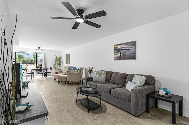 living room featuring baseboards, wood tiled floor, and ceiling fan