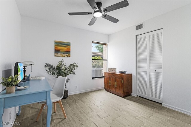 home office featuring a ceiling fan, baseboards, visible vents, and light wood-style floors