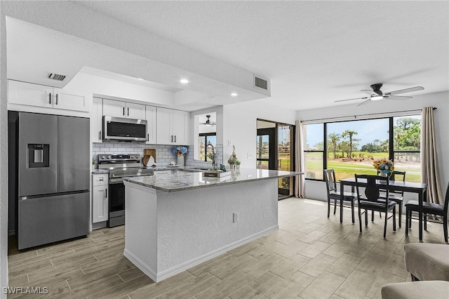 kitchen featuring visible vents, a ceiling fan, and stainless steel appliances