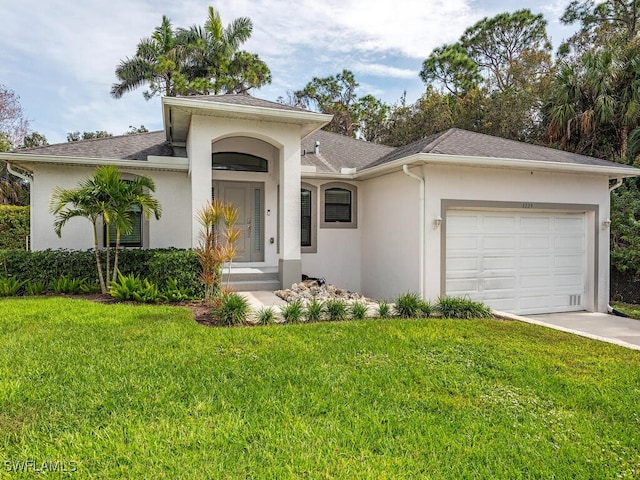view of front of property with concrete driveway, an attached garage, a front yard, and stucco siding