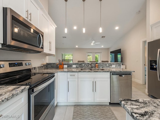 kitchen featuring a peninsula, light tile patterned flooring, white cabinets, a ceiling fan, and appliances with stainless steel finishes