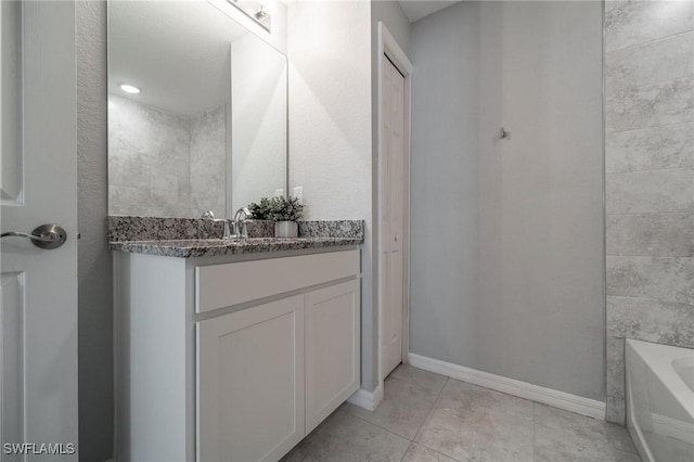 403 NW 17th Ter, Cape Coral, FL 33993 - bathroom with a washtub, tile patterned floors, baseboards, and vanity
