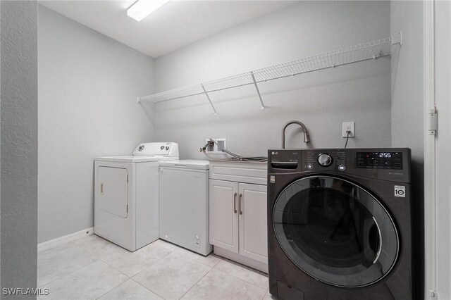 403 NW 17th Ter, Cape Coral, FL 33993 - laundry room with light tile patterned floors, baseboards, independent washer and dryer, and cabinet space