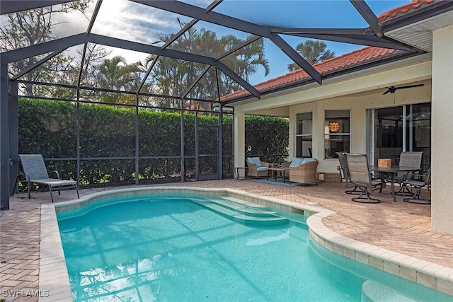 outdoor pool with a patio and glass enclosure