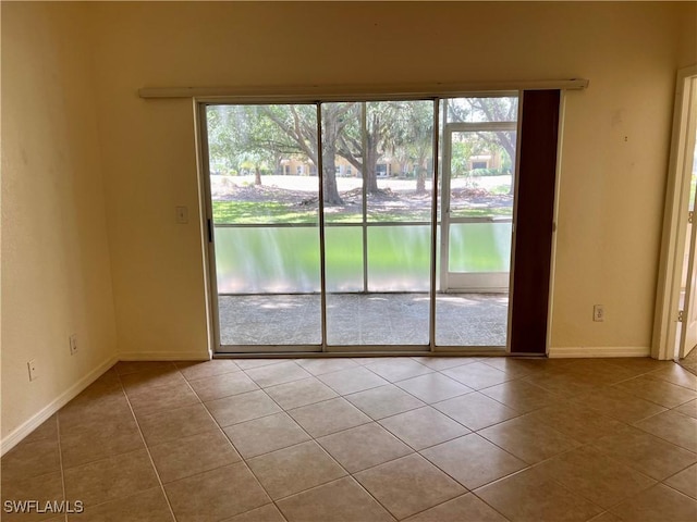 unfurnished room featuring baseboards and tile patterned floors