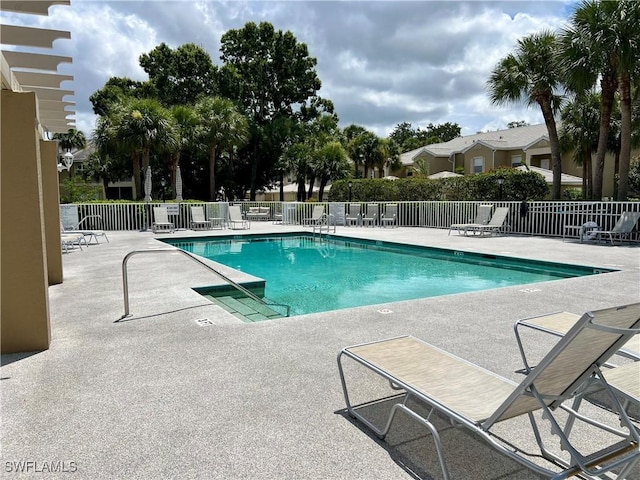pool featuring fence and a patio area
