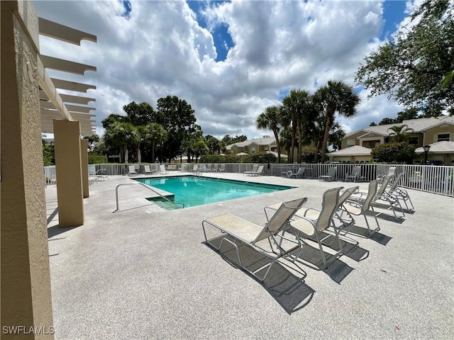 pool with a patio area and fence