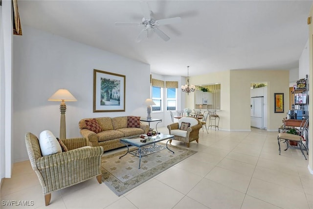 living room featuring light tile patterned floors, baseboards, and ceiling fan with notable chandelier