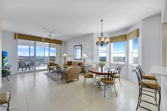 dining area featuring light tile patterned flooring, plenty of natural light, and ceiling fan with notable chandelier