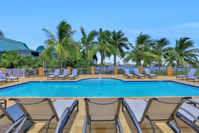 community pool with fence and a patio