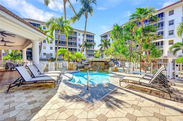 community pool with fence, a patio area, and ceiling fan