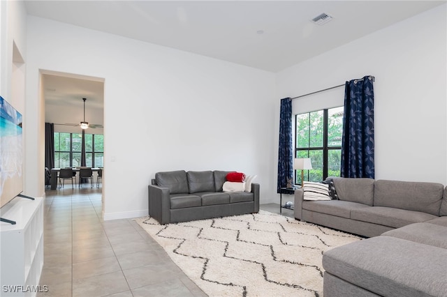 living room featuring baseboards, ceiling fan, visible vents, and light tile patterned floors