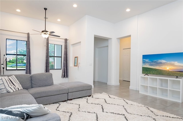 living area with tile patterned floors, ceiling fan, baseboards, and recessed lighting