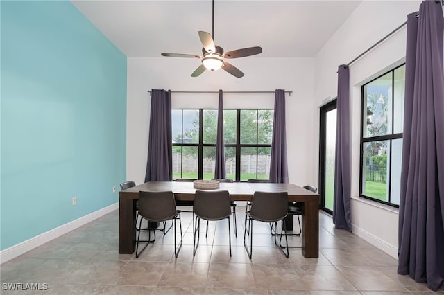 dining area featuring a healthy amount of sunlight, baseboards, ceiling fan, and light tile patterned floors