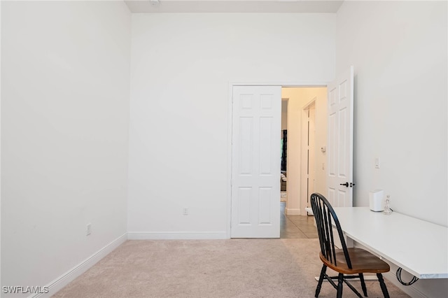 unfurnished office featuring baseboards and light colored carpet