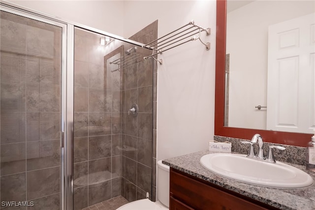 full bathroom featuring vanity, toilet, and a shower stall