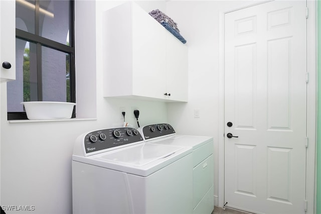clothes washing area with cabinet space and washer and dryer