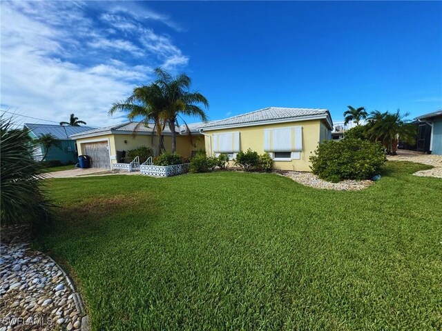 12 Bayview Blvd, Fort Myers Beach, FL 33931 - ranch-style home featuring stucco siding, an attached garage, driveway, and a front yard