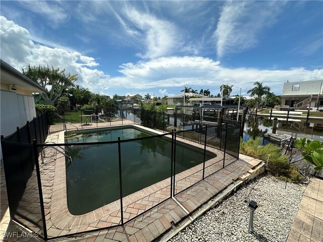 12 Bayview Blvd, Fort Myers Beach, FL 33931 - view of pool featuring a fenced in pool, a boat dock, boat lift, and a water view