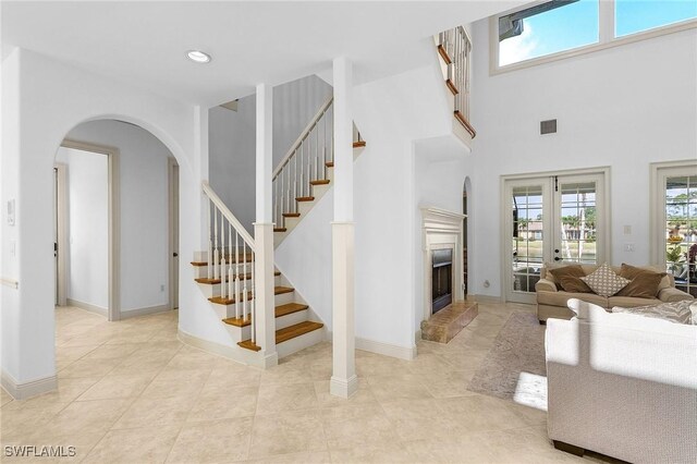 4009 Treadwater Ct, Naples, FL 34109 - stairs featuring visible vents, arched walkways, baseboards, a fireplace with raised hearth, and recessed lighting