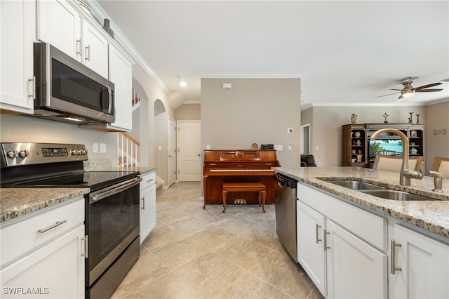 kitchen featuring a sink, ornamental molding, a ceiling fan, white cabinets, and appliances with stainless steel finishes
