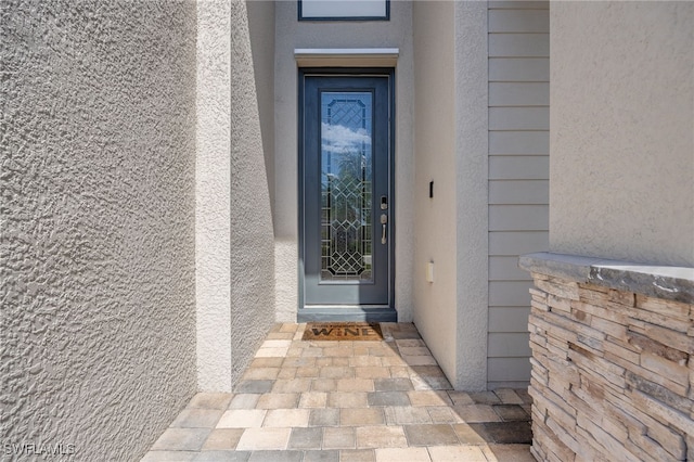 view of exterior entry featuring stucco siding