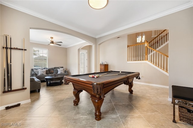 game room featuring crown molding, tile patterned flooring, baseboards, and arched walkways